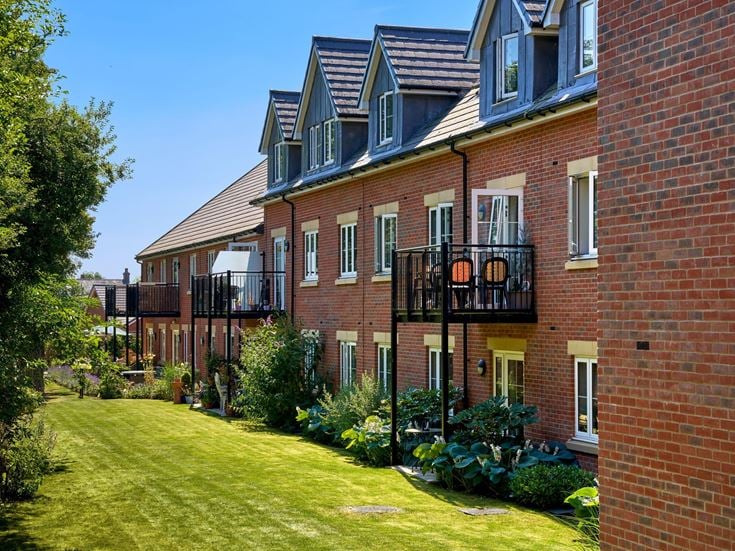 a brick building with a green lawn