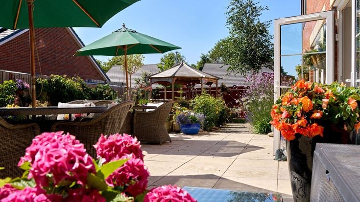 a patio with umbrellas and flowers