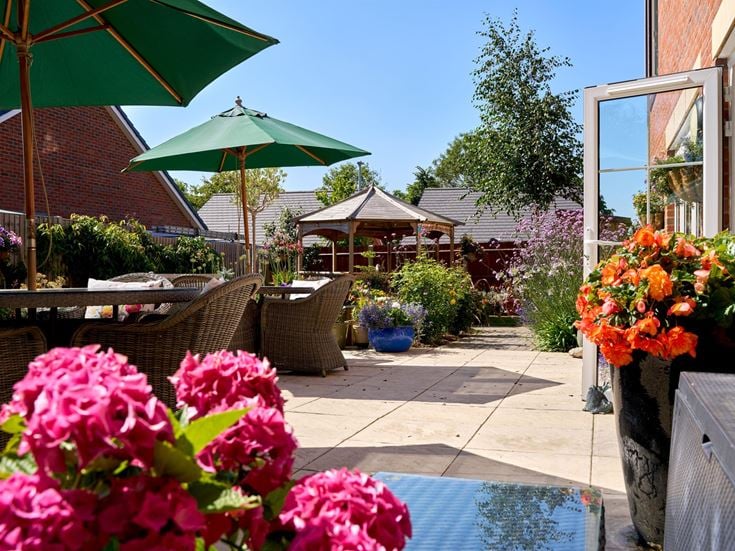 a patio with umbrellas and flowers