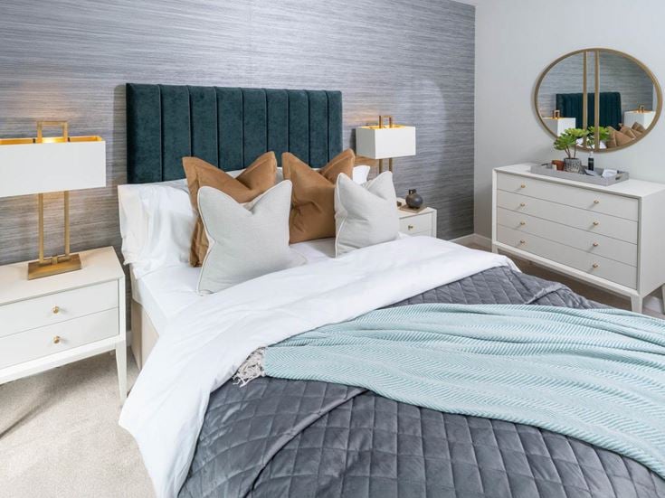 a bed with a mirror on the wall