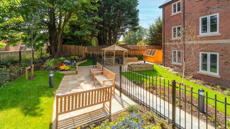 a fenced in yard with a bench and a building