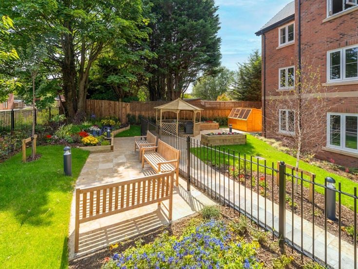 a fenced in yard with a bench and a building