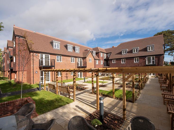 a brick building with a patio and chairs in front of it