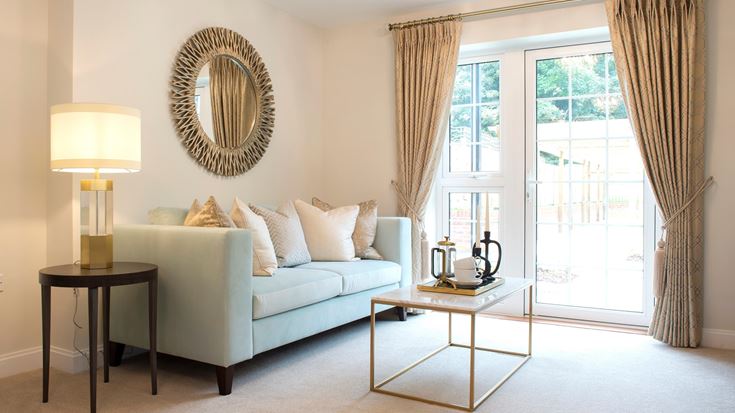 a living room with a white couch and a round mirror
