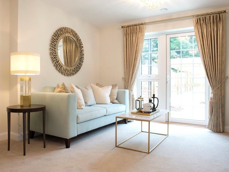 a living room with a white couch and a round mirror