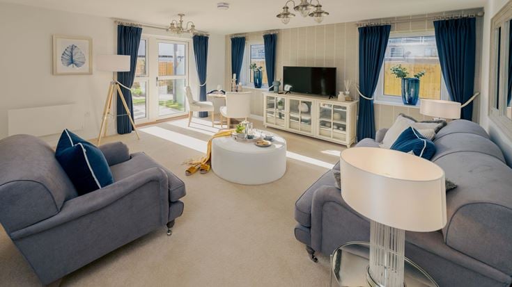 a living room with a blue couch and a white table