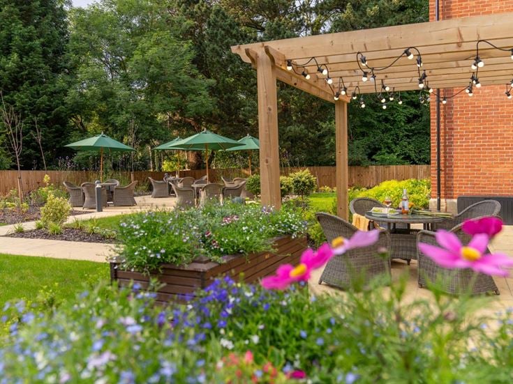 a garden with a table and chairs