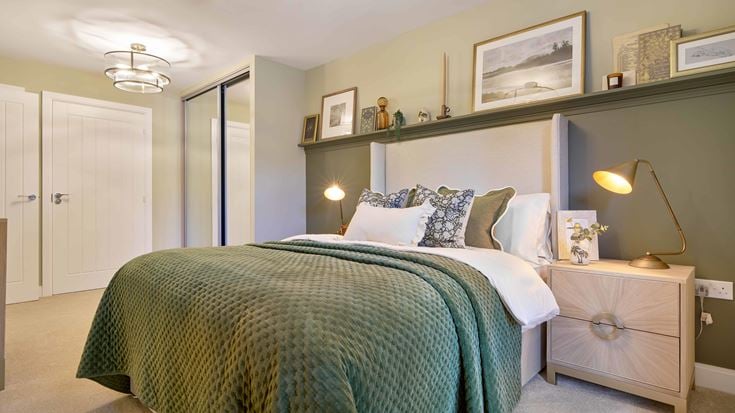 a bed with a green comforter
