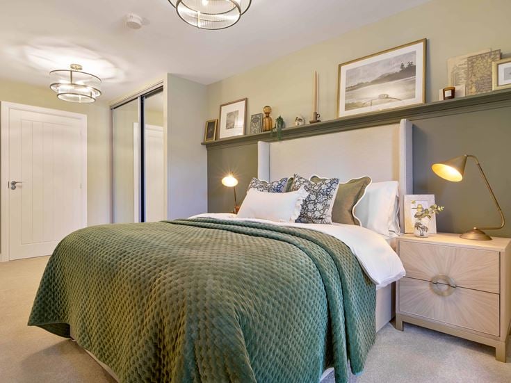 a bed with a green comforter