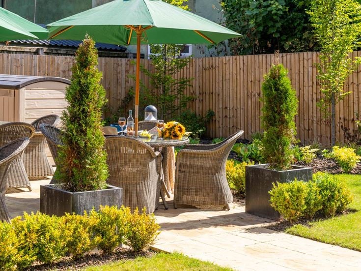 a patio with a table and chairs and umbrella