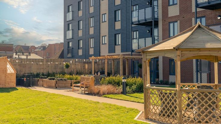 a backyard with a fence and a lawn and a building