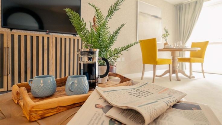 a table with a vase and a potted plant on it