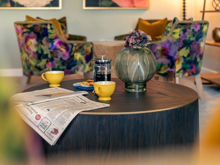 a table with a vase and glasses on it