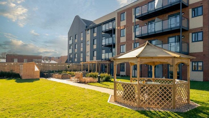 a building with a deck and a lawn in front of it