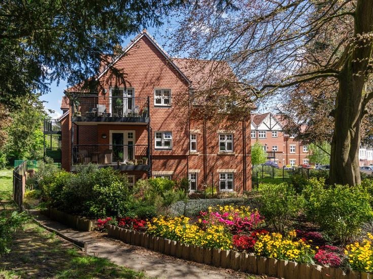 a large brick building with a garden in front of it
