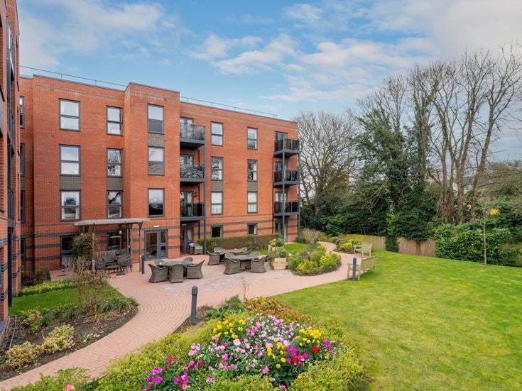 a brick building with a garden in front of it