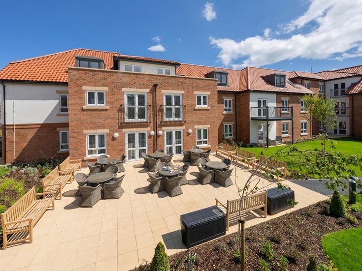 a brick building with a garden in front of it