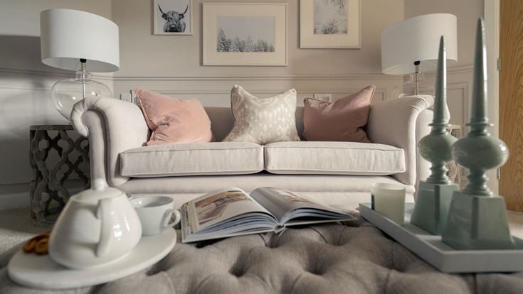 a white couch with pillows and a lamp on it