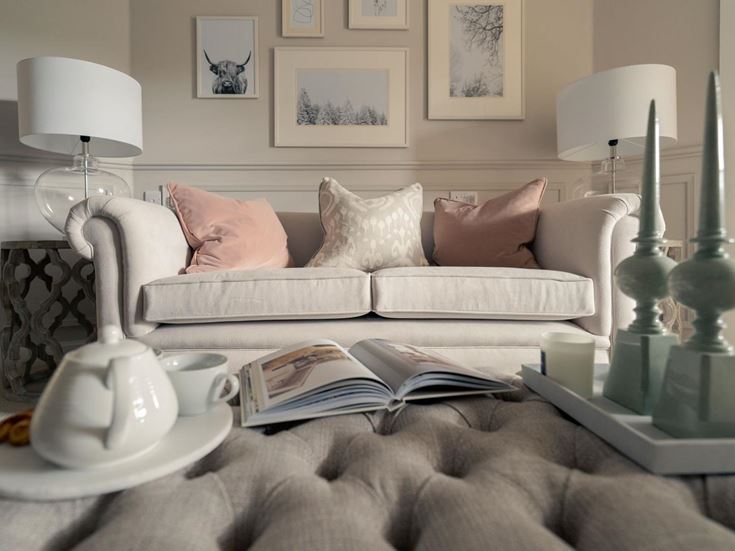 a white couch with pillows and a lamp on it