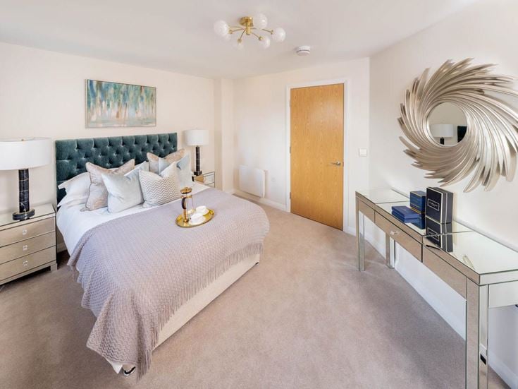a bedroom with a bed desk and a mirror