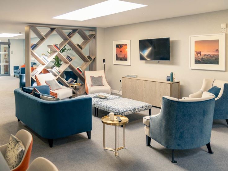 a living room with blue chairs and a table