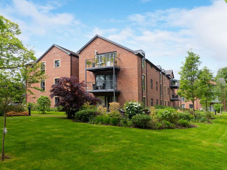 a brick building with trees and grass