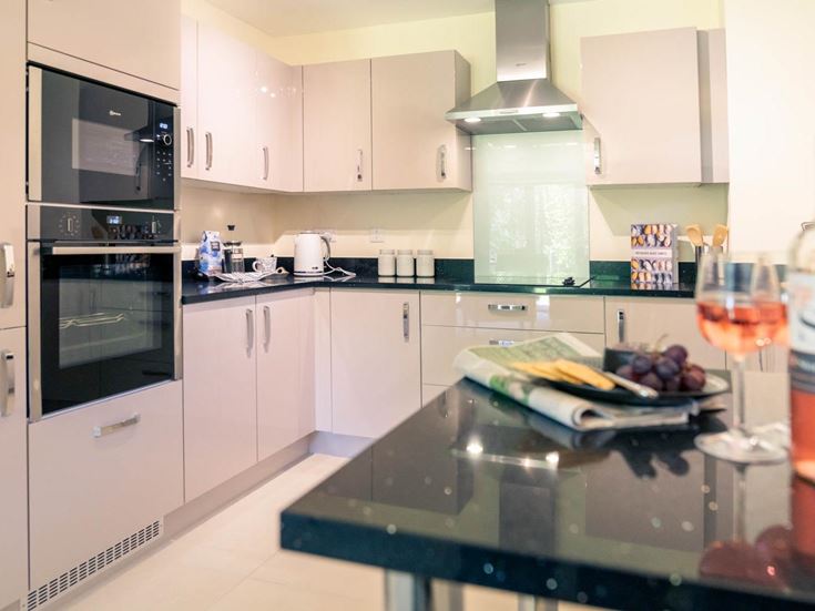 a kitchen with a glass of wine