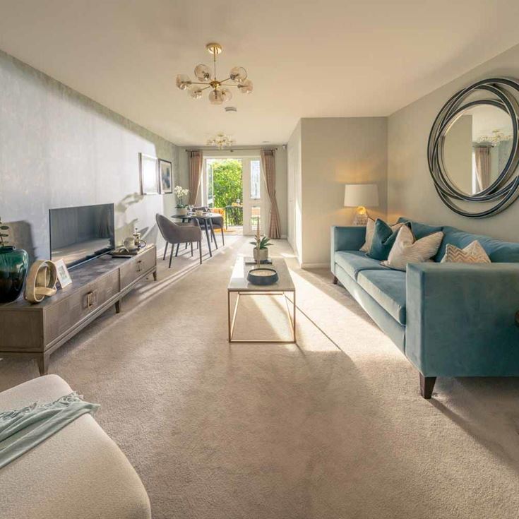 a living room with a blue couch and a round mirror
