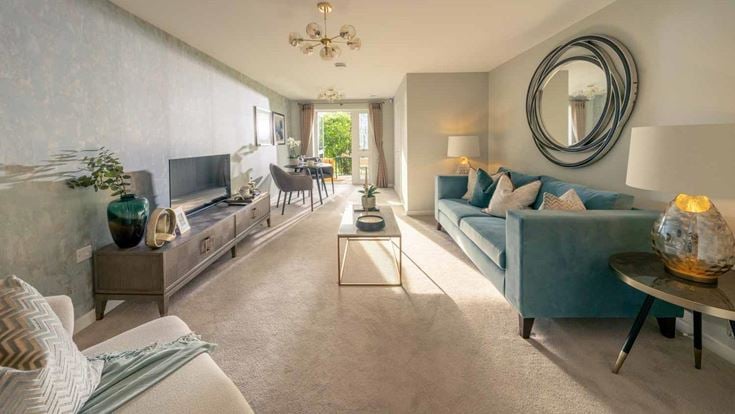 a living room with a blue couch and a round mirror
