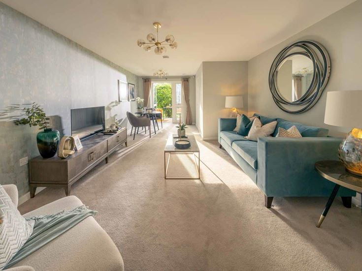 a living room with a blue couch and a round mirror