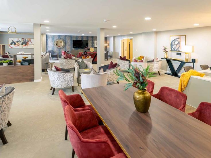 a large living room with a table and chairs