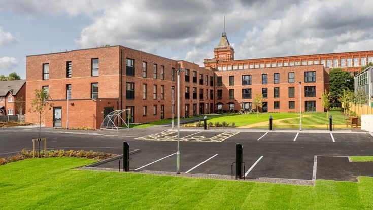 a large brick building with a parking lot in front of it