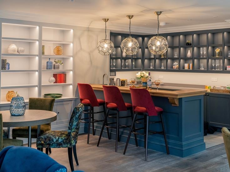 a room with a table chairs and a shelf with lights
