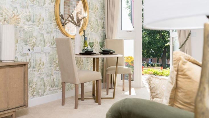 a room with a table chairs and a mirror