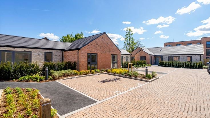 a brick road with bungalows either side of it