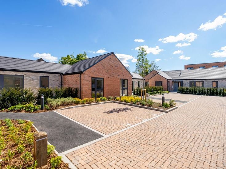 a brick road with bungalows either side of it