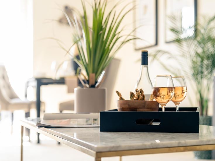 a table with wine glasses and a plant on it