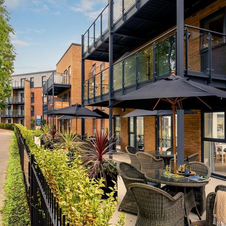 a patio with tables and chairs outside a building