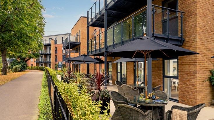 a patio with tables and chairs outside a building