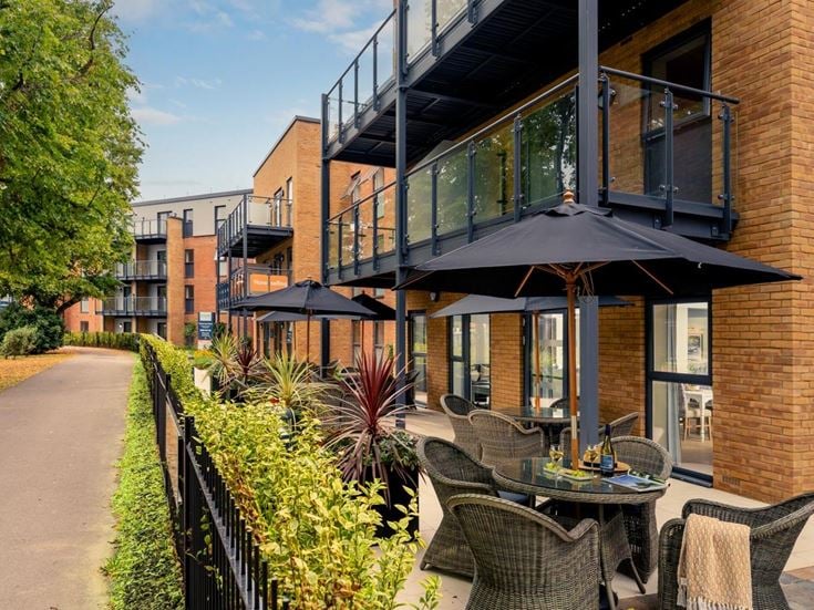 a patio with tables and chairs outside a building