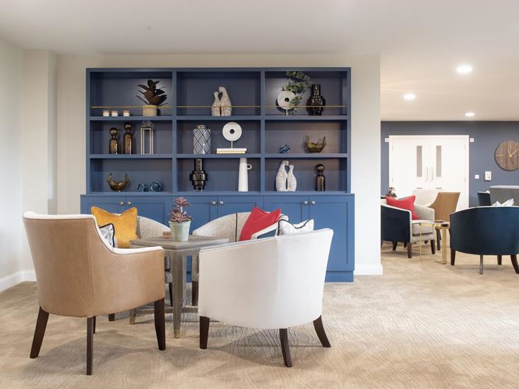 a room with a table chairs and a shelf with objects on it
