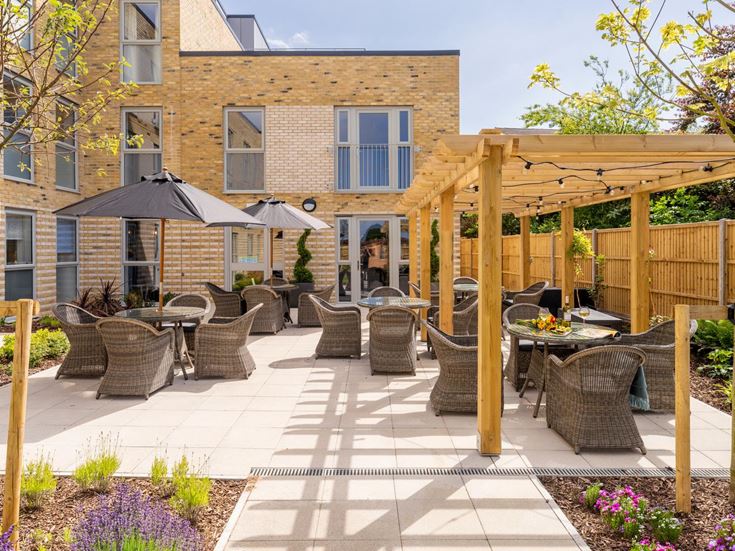 a patio with chairs and tables and umbrellas in front of a building