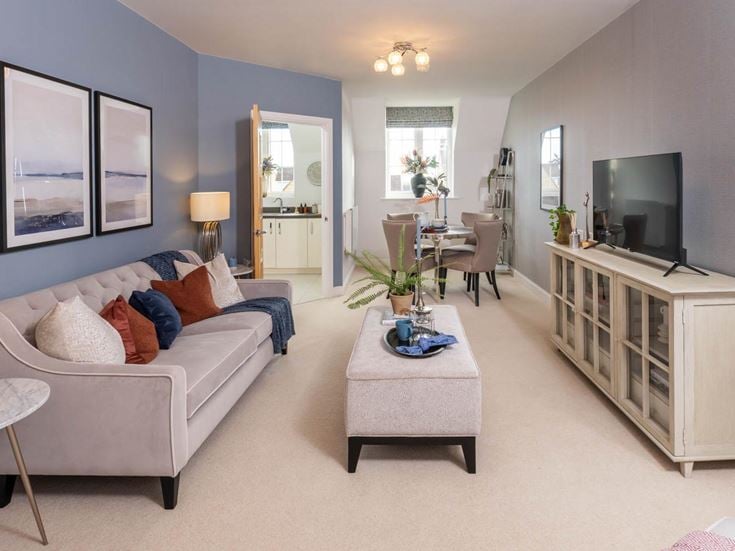 a living room with a white couch and a tv