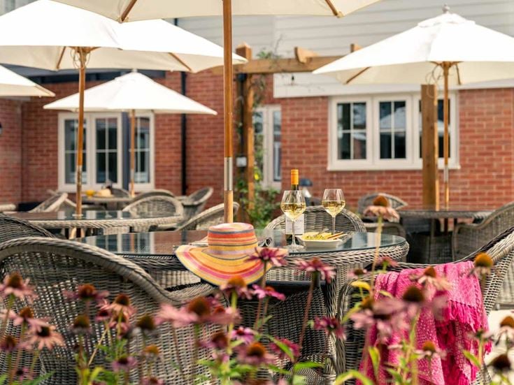 a table with umbrellas and chairs outside of a restaurant