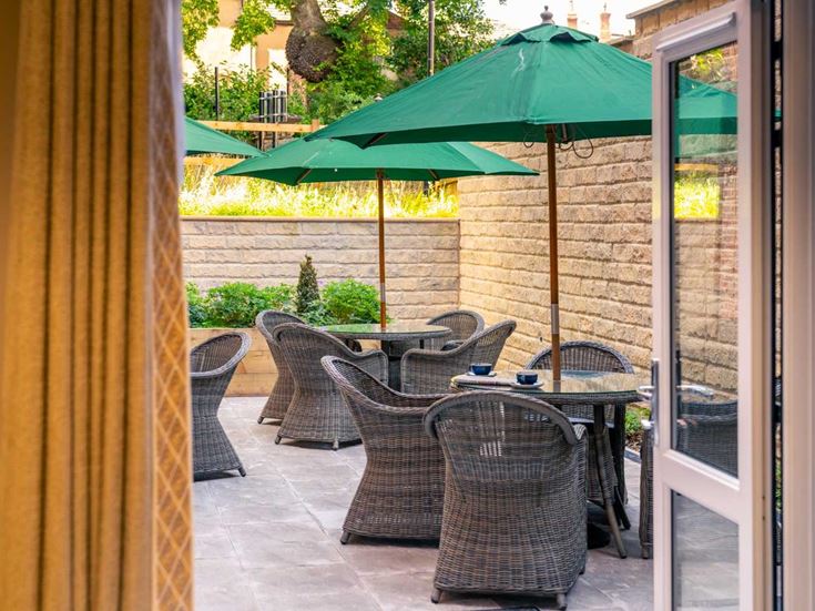 a patio with chairs and umbrella