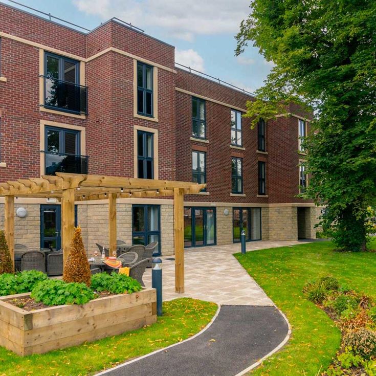 a building with a walkway and a lawn in front