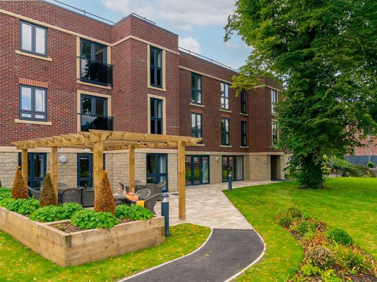 a building with a walkway and a lawn in front