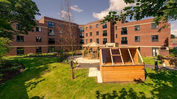 a small wooden structure in front of a brick building