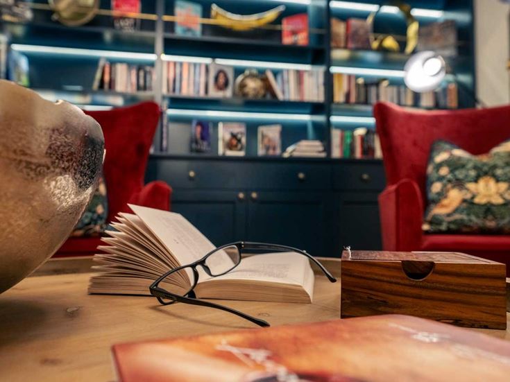 a living room with a large round table and bookshelf