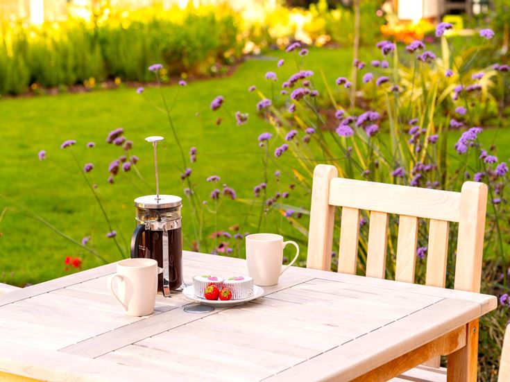 a table with a vase and cups on it
